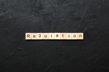 regulation word written on wood block. regulation text on table, concept