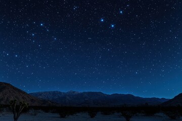 A night sky filled with stars over a mountain range.