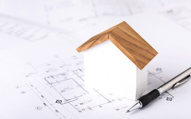 Concept of building permit application, featuring a house model and construction plans placed on a...