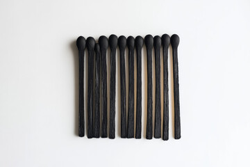 A set of black matchsticks, each with its own head on the end and made from a wooden material. Created with Ai