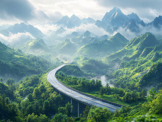 serene mountain road winding through lush green valley with misty peaks - stock photo