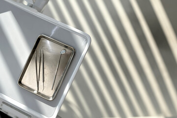 Close-up of Dental Tools on a Metal Tray in Sunlight - Minimalist Dental Equipment in a Modern Clinic Setting