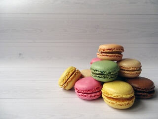 Pastelowe francuskie makaroniki ułożone w piramidę na jasnym tle z dużą przestrzenią roboczą po lewej stronie