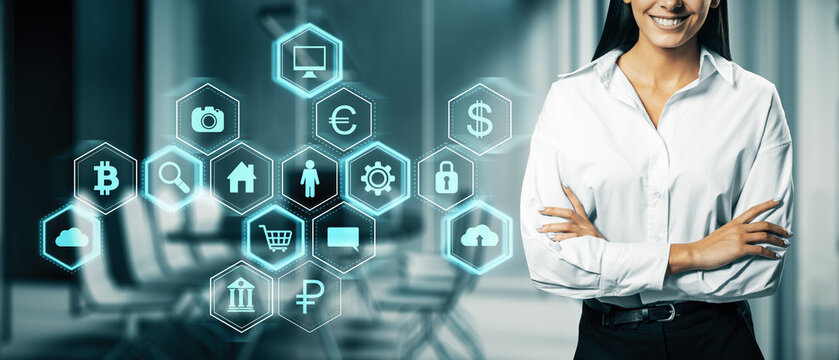 Close up of smiling businesswoman folded arms and digital business interface hologram on blurry office interior background. Technology and information concept.