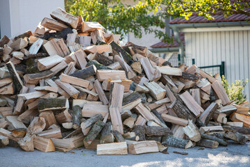 Tas de morceaux de bois pour le chauffage poser en extérieur, attendant d'être rangé dans un...