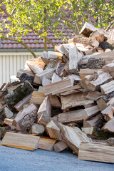Tas de morceaux de bois pour le chauffage poser en extérieur, attendant d'être rangé dans un abri. Bois coupé pour le chauffage des maisons, prêt à être stocker pour sécher.