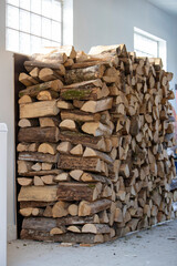 Morceaux de bois pour le chauffage empilés en attendant d'être utilisés en hiver dans un garage. Bois coupé pour le chauffage des maisons, pile de bois de chauffage sur un tas.