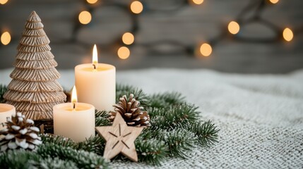 Christmas decorations with candles, pine, and a wooden tree on a cozy, soft blanket and warm, festive lights.
