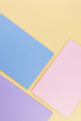 Top view of pink, purple and blue notebooks on yellow background. School, office wallpaper. Flat lay, copy space.