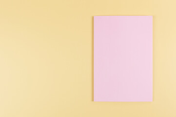 Fototapeta premium Top view of pink notebook on yellow background. School, office wallpaper. Flat lay, copy space.