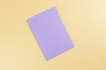 Top view of purple notebook on yellow background. School, office wallpaper. Flat lay, copy space.