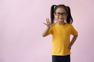 Close-up photo of a cute little girl, cheerful, smart, good at learning, new ideas, and imagination. Expressing various poses based on bright life concept, copy space, and pink pastel background.