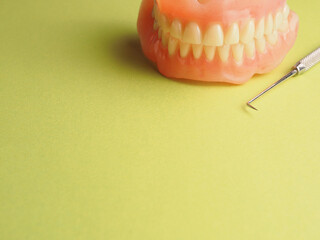 Dentures on a green background with space for your text or product