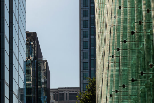 Modern city skyline featuring layers of architectural styles, where glass structures and an innovative green building showcase a complex urban tapestry.