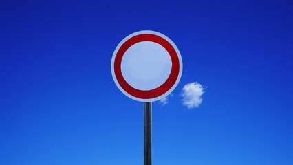 Red Circle Traffic Sign Against Blue Sky with a Single White Cloud