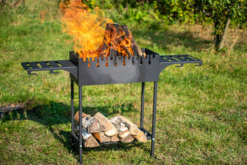 Brazier with burning wood on a summer sunny day