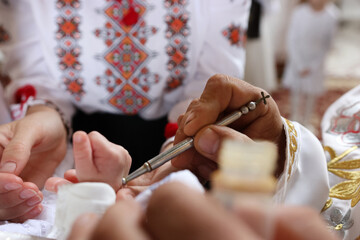 The priest performs the rite of baptism and anointing.