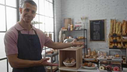 Young man presenting baked goods in a cozy bakery with a welcoming smile and shelves filled with a variety of fresh pastries and breads