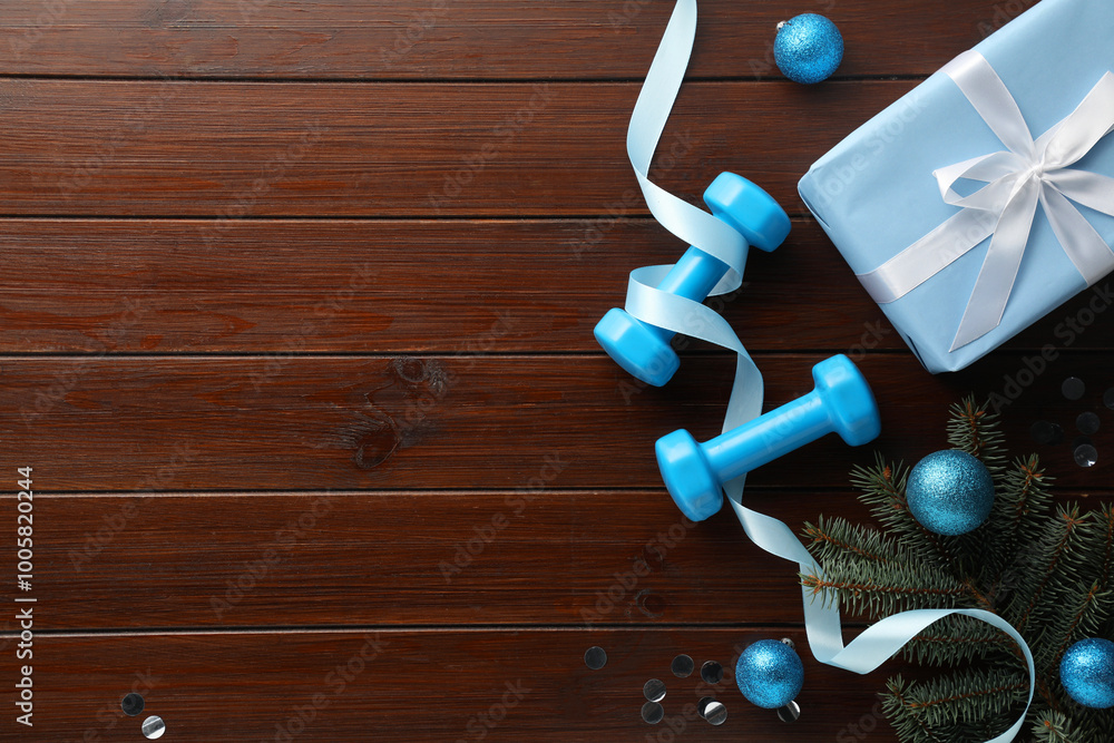 Poster Dumbbells, fir tree branches and Christmas decor on wooden table, flat lay. Space for text