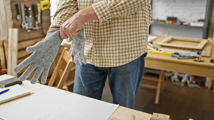 Grey-haired man in plaid shirt preparing for woodwork in a workshop