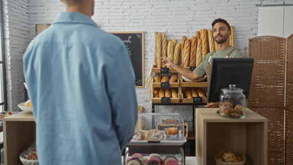 Baker serving man in a bakery shop interior with various breads behind a counter