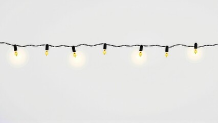 Minimalist string of golden Christmas lights against a soft background.