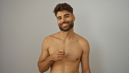 Young hispanic man pointing at the camera with a smile, isolated on a white background, showcasing his handsome and attractive features.