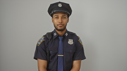 Portrait of an authoritative african american police officer isolated against a white background,...