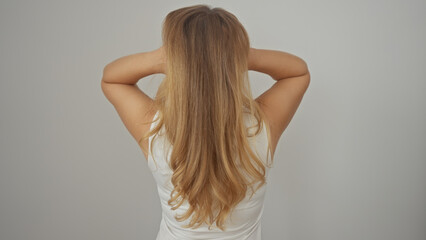 Obraz premium Back view of a young caucasian woman with long blonde hair, standing isolated against a white background.