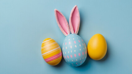 Fototapeta premium A collection of pastel-colored Easter eggs with decorative blue flowers and pampas grass on a blue background.
