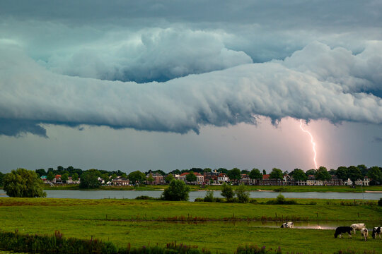 Dramatic looking sky as a shelf cloud from a severe thunderstorm approaches while lightning strikes