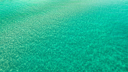 Aerial view of the sea surface with Caribbean colors of San Pietro in Bevagna in Puglia, Italy. Ideal for backgrounds, textures and patterns. © Stefano Tammaro