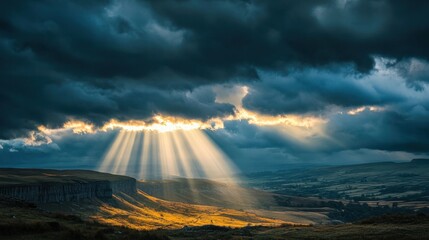 Sunlight breaking through storm clouds, casting dramatic rays of light onto the land below