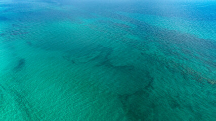 Aerial view of the sea surface with Caribbean colors of San Pietro in Bevagna in Puglia, Italy....