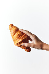 Croissant in a person's hand on a white background
