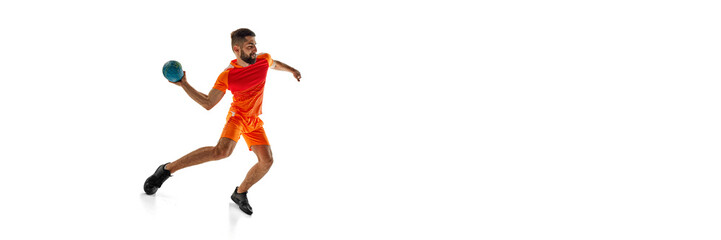 Competitive young man, handball player in motion during intense game, playing isolated on white...