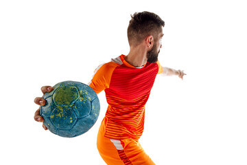 Dynamic image of young bearded man in orange uniform, handball player in motion, playing, training...