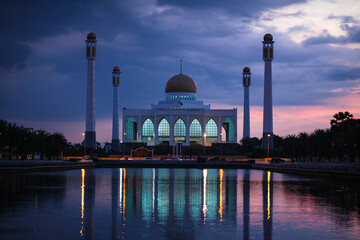 A large white Mosque with The water is calm and reflects the twilight sky, Central Mosque Songkhla,...