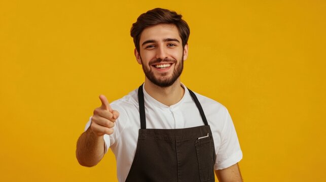 A restaurant waiter smiling and pointing finger directly at the viewer, isolated on a solid yellow background,   ideal for service, hospitality, and customer engagement themes.