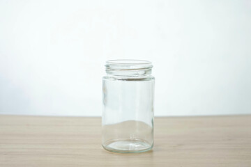 An empty clear glass is placed on a wooden patterned table isolated on a white background
