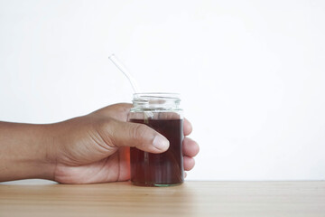 man's hand holding a glass of tea isolated on white background