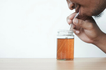 a man is drinking tea using a glass 