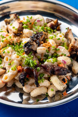 GRILLED CHICKEN MACARONI SALAD served in plate isolated on blue background closeup top view of protein salad
