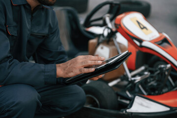 Obraz premium Digital tablet, quality control. Man is outdoors, kart racing conception