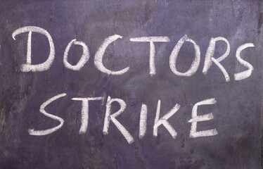 Fototapeta premium Doctors Strike Phrase Written on Blackboard with White Chalk