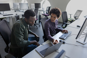 Coworkers discussing computer software in office