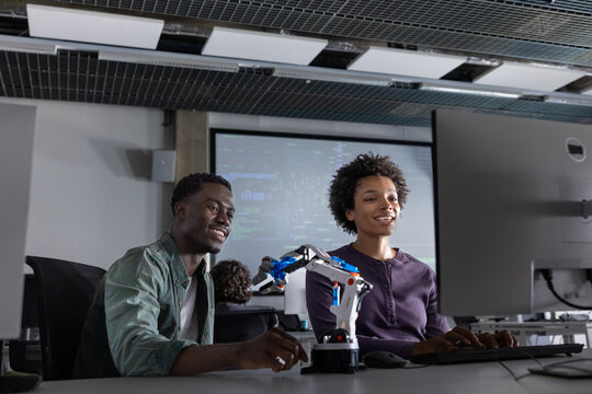 Students working late programming a robotic arm 