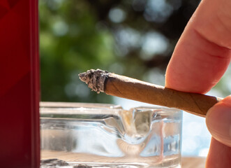 Cigar in hand close-up on blurred background