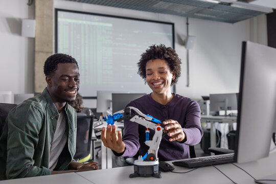 Happy students programming a robotic arm