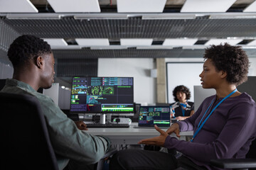 Coworkers discussing computer program in office